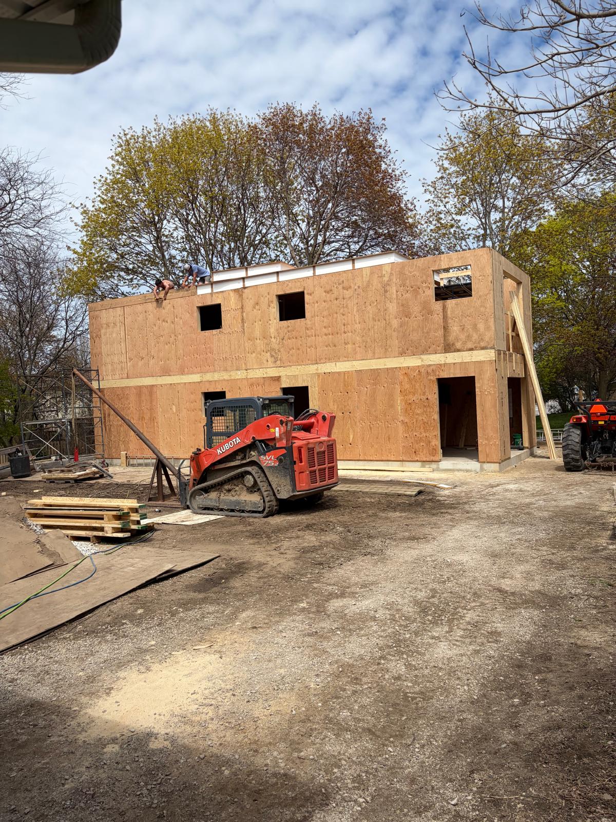 Front exterior view of completed two-story SIP panel home structure with windows and door openings
